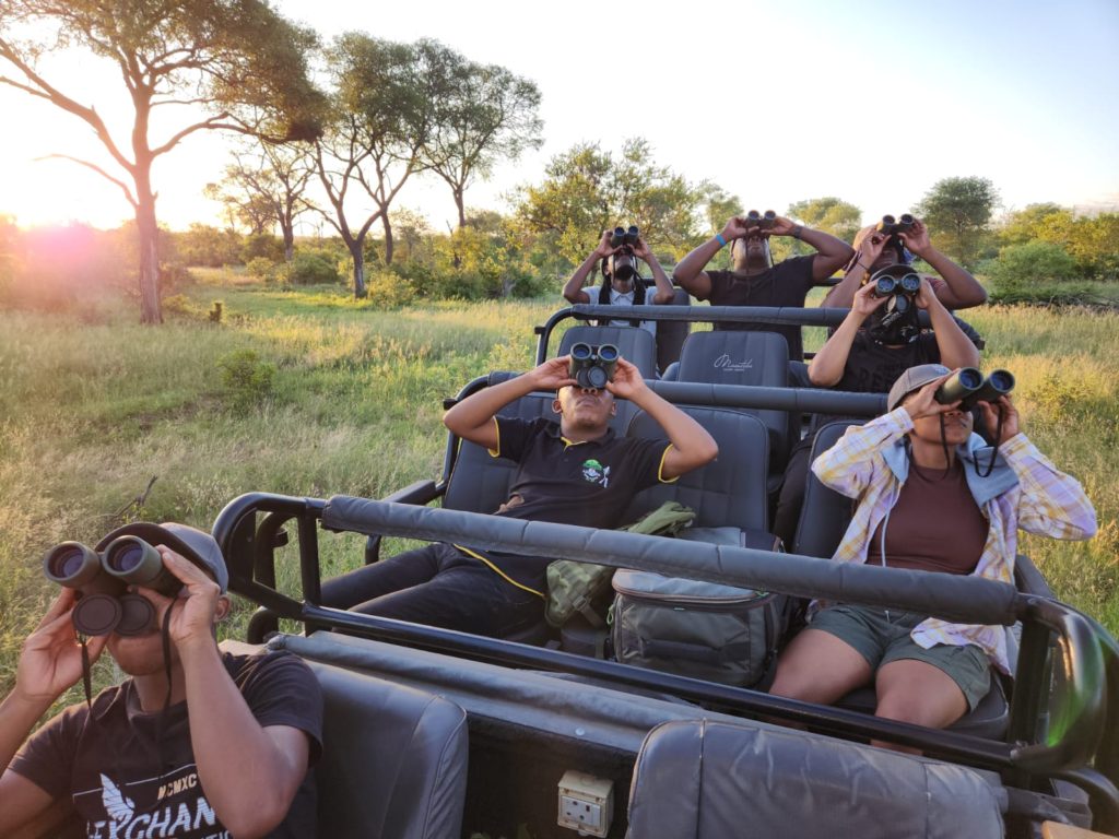students-using-binoculars-while-sitting-in-a-safari-vehicle
